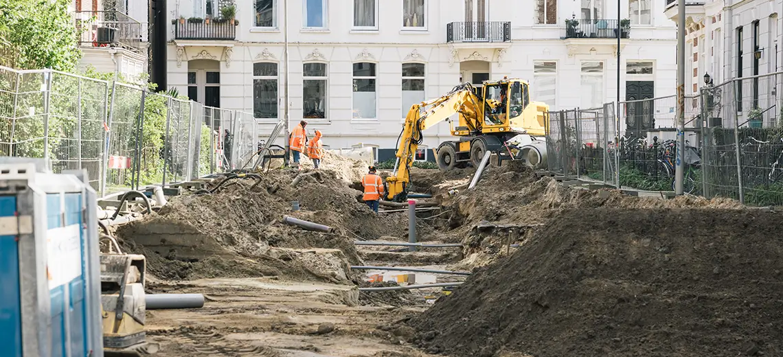 mannen in Civiele Techniek werkend aan openliggende weg